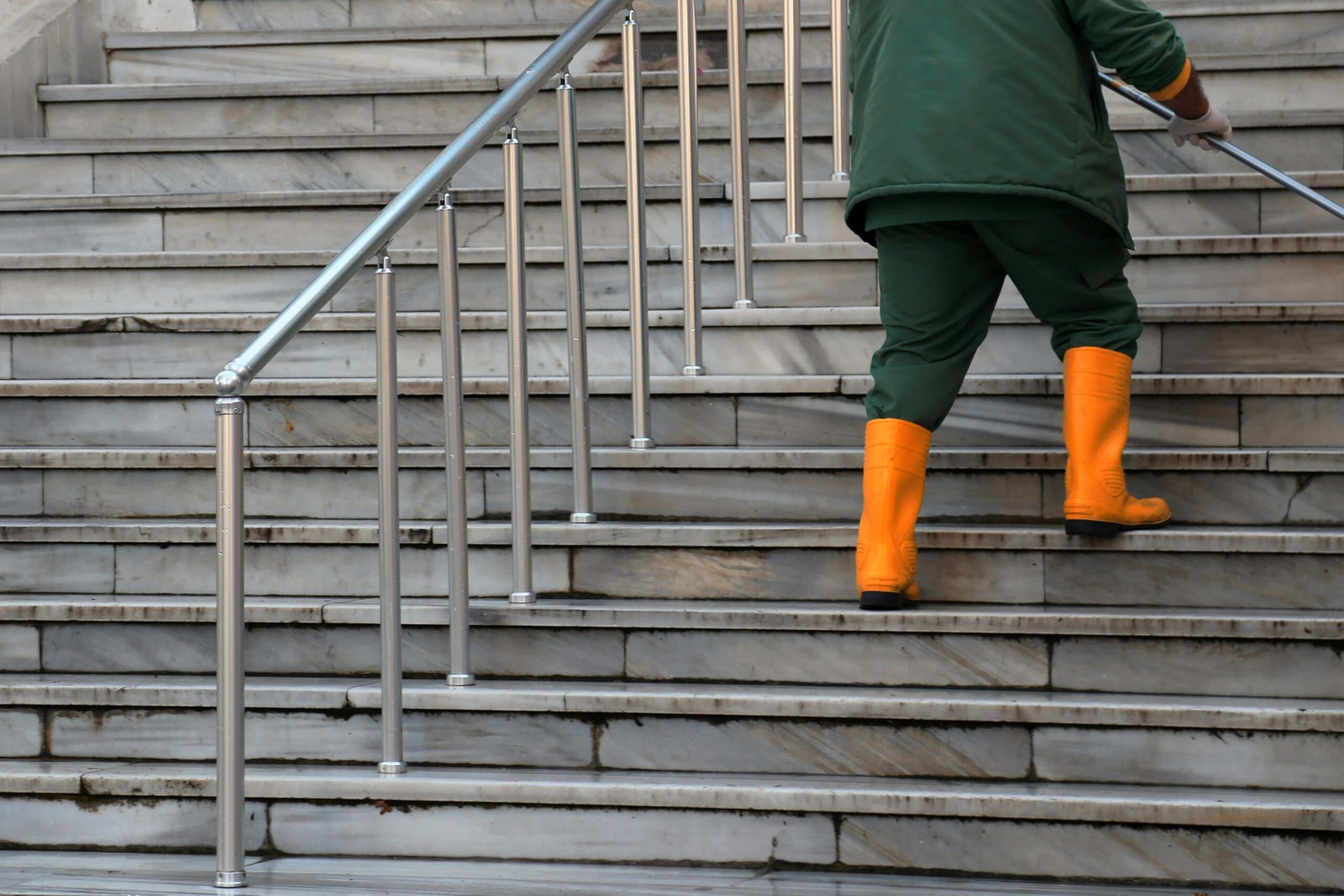 Persona limpiando una escalera  en comunidad. Servicio de limpieza profesional para escaleras y comunidades en Madrid por MasterCleen.